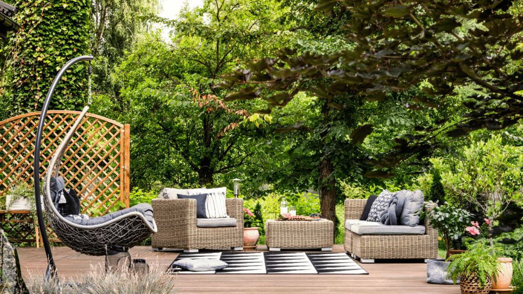 Deck with wicker furniture surrounded by plants | Stay Cool in Backyard