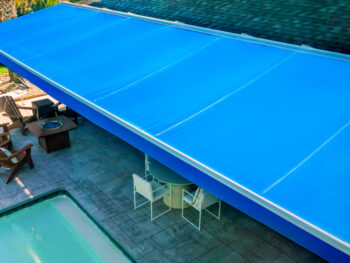 Large blue motorized awning ariel view poolside