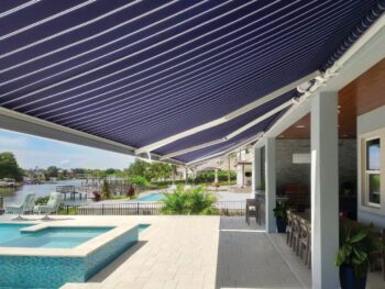 Blue and white striped motorized awning underside view poolside